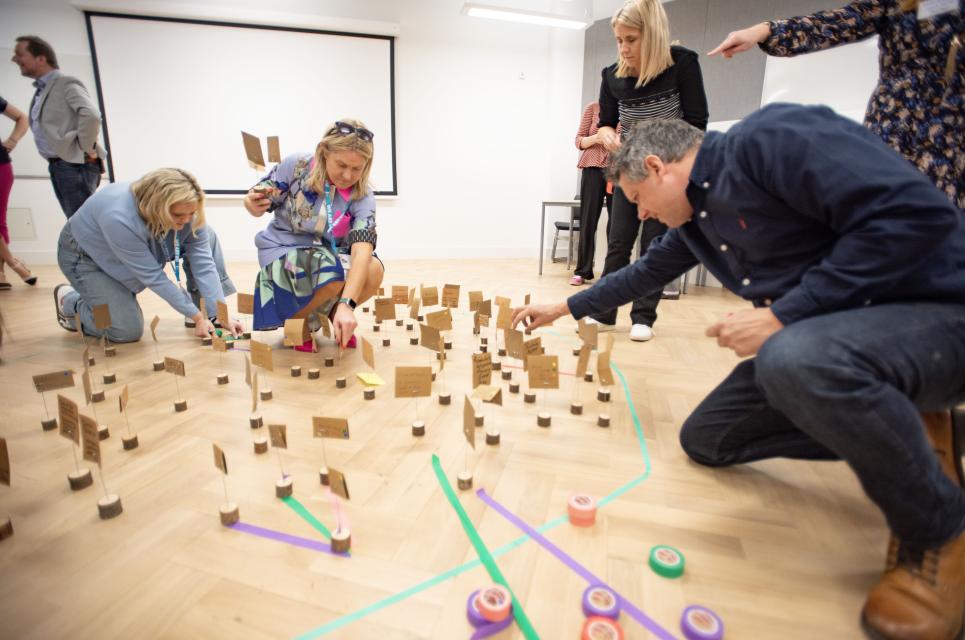 Image of roundtable guests creating a network map on the floor