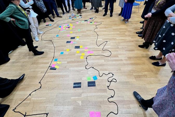 Delegates gathered around a map on the floor - connections within the ecosystem.